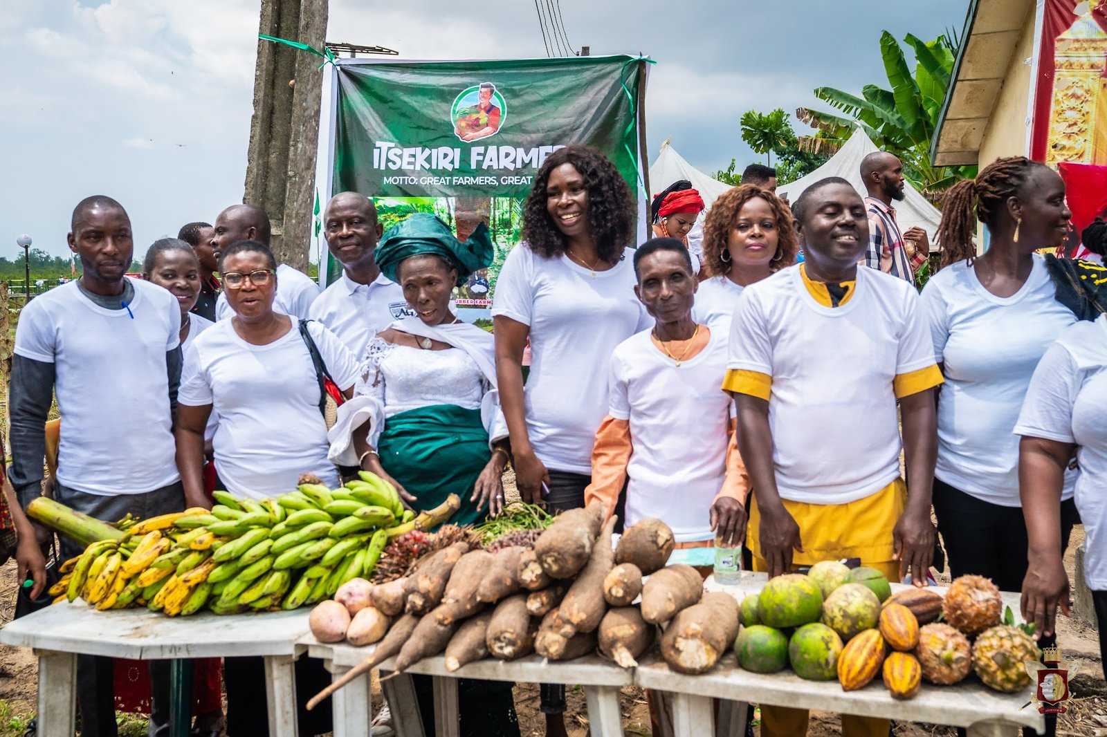 Ìtsẹ̀kírì farmers gathered behind a display of local produce